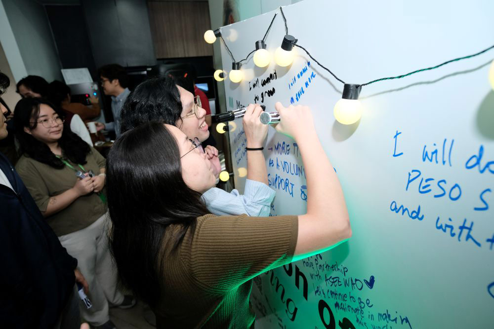 Manulife Philippines colleagues write in the commitment wall during the Season of Giving launch